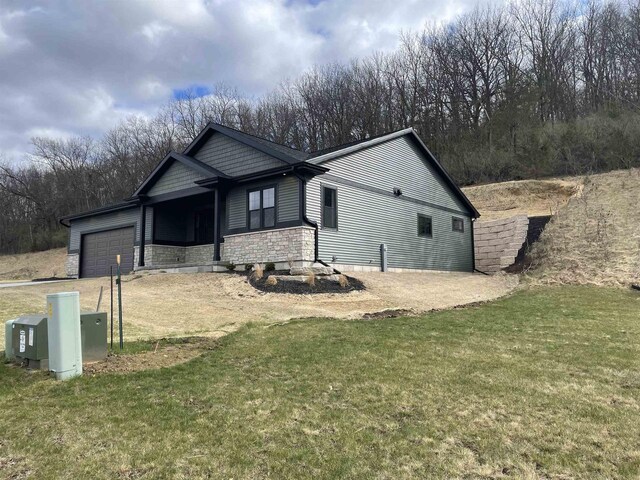 4021 Red Hawk Run, Black Earth, WI 53515 - view of property exterior featuring stone siding, a lawn, and a garage