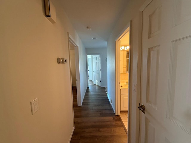 hallway with baseboards and dark wood-style flooring