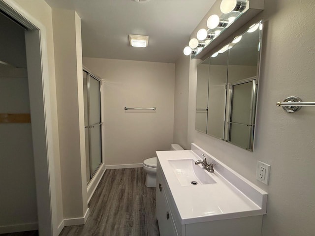 full bath with toilet, wood finished floors, a shower stall, and vanity