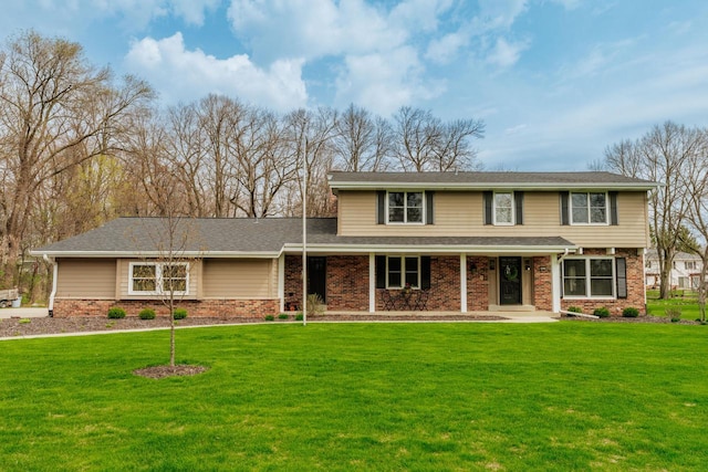 traditional-style home with a front lawn, a porch, and brick siding