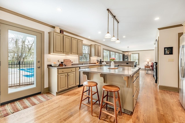 kitchen featuring appliances with stainless steel finishes, a breakfast bar area, and ornamental molding