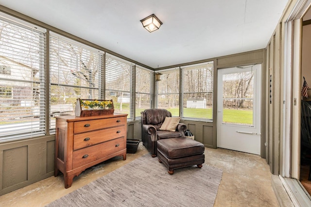 sunroom featuring a wealth of natural light and unfinished concrete flooring