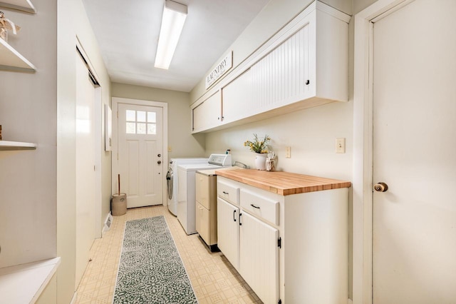 laundry area featuring light floors, washer and clothes dryer, and cabinet space