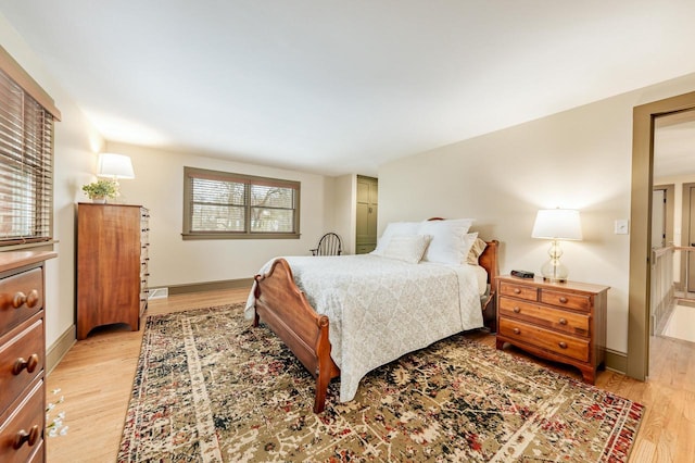 bedroom featuring light wood finished floors and baseboards