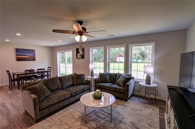 10230 Olker Rd, Hayward, WI 54843 - living area featuring baseboards, wood finished floors, visible vents, and ceiling fan