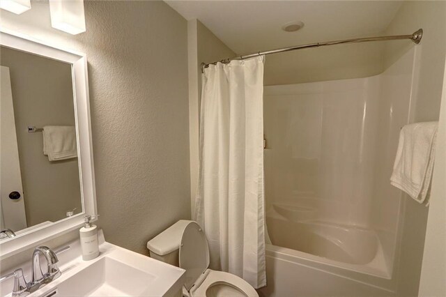 10230 Olker Rd, Hayward, WI 54843 - full bath featuring a textured wall, shower / tub combo with curtain, vanity, and toilet