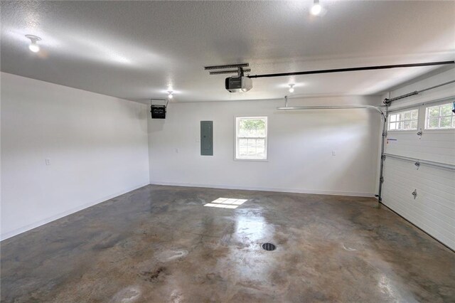 10230 Olker Rd, Hayward, WI 54843 - garage featuring a garage door opener, electric panel, and baseboards