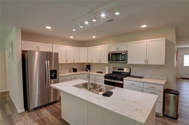 10230 Olker Rd, Hayward, WI 54843 - kitchen with wood finished floors, a sink, stainless steel appliances, white cabinetry, and visible vents