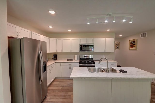 10230 Olker Rd, Hayward, WI 54843 - kitchen with white cabinets, stainless steel appliances, a sink, visible vents, and light wood-style floors