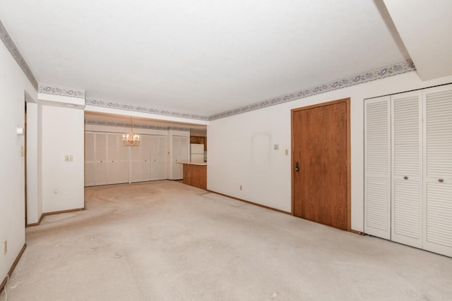 interior space with light colored carpet, baseboards, and a chandelier