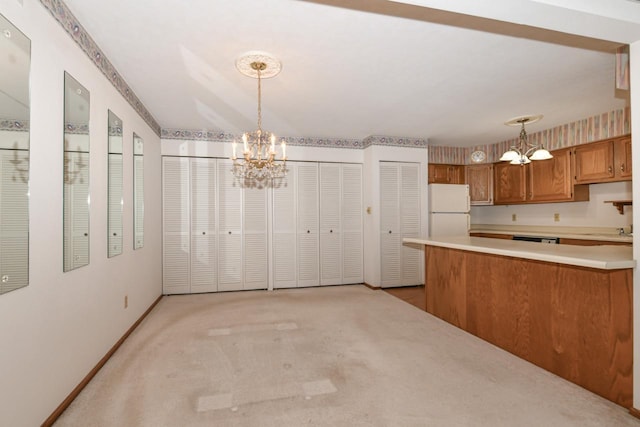 kitchen with brown cabinetry, an inviting chandelier, light carpet, light countertops, and freestanding refrigerator