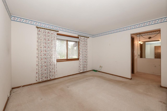 unfurnished room with carpet floors and baseboards