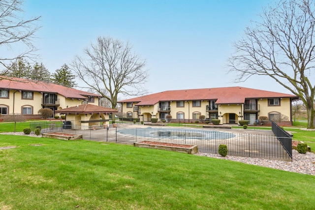 community pool featuring a lawn and fence
