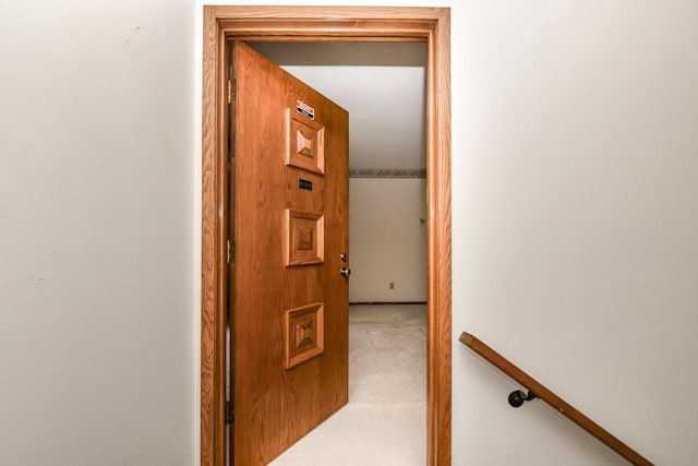 corridor featuring carpet flooring and an upstairs landing