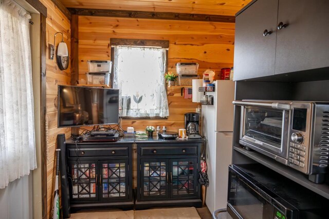 W4742 26th St, Necedah, WI 54646 - kitchen featuring wood walls and freestanding refrigerator