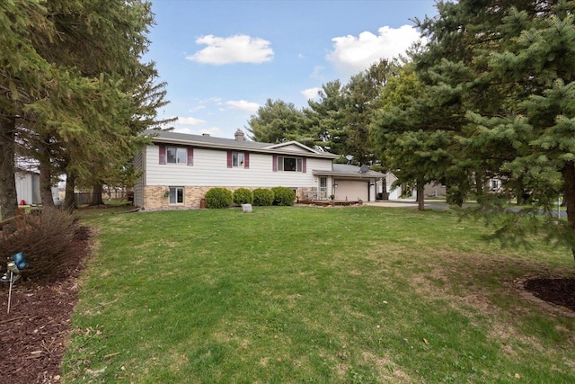 view of front of house featuring an attached garage, driveway, and a front yard
