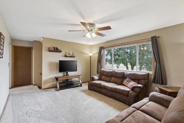 carpeted living area with baseboards and a ceiling fan