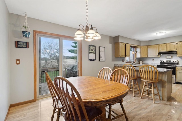 dining space with light wood-style flooring, baseboards, and a chandelier