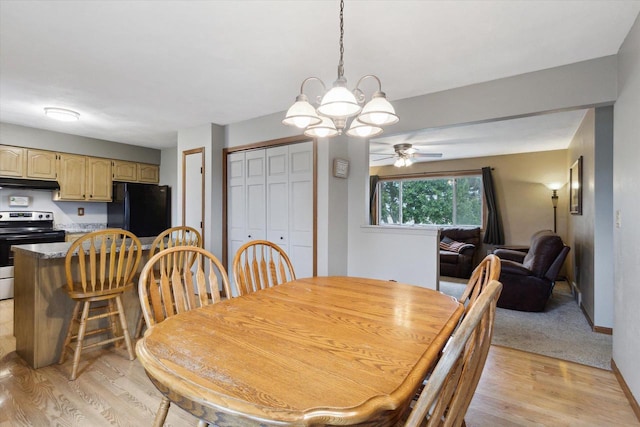 dining area with baseboards, light wood-style floors, and ceiling fan with notable chandelier