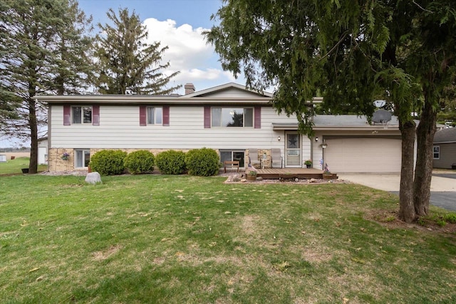 tri-level home with a chimney, a front lawn, concrete driveway, a wooden deck, and a garage