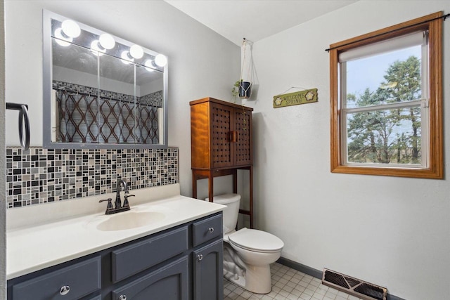 bathroom featuring tile patterned flooring, visible vents, toilet, vanity, and tasteful backsplash