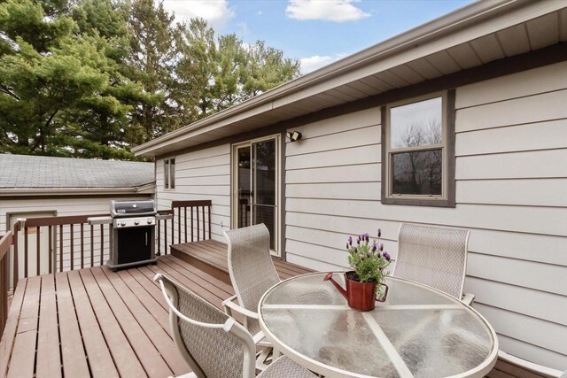 wooden terrace with outdoor dining area and a grill