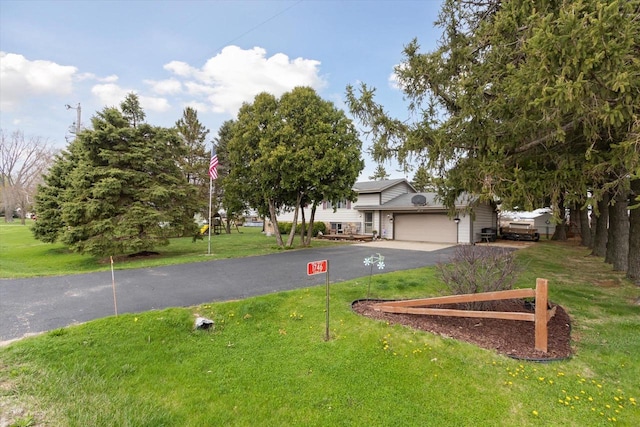 view of front facade featuring aphalt driveway, a front yard, and a garage
