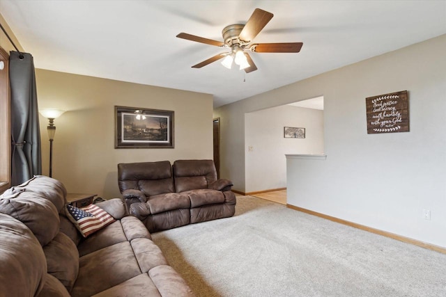 living area with baseboards, a ceiling fan, and carpet flooring