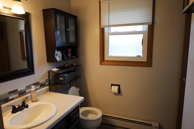 2282 Collier Ct, Green Bay, WI 54311 - bathroom featuring a baseboard radiator, toilet, vanity, and backsplash