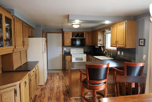 2282 Collier Ct, Green Bay, WI 54311 - kitchen featuring white appliances, a sink, dark countertops, a peninsula, and backsplash