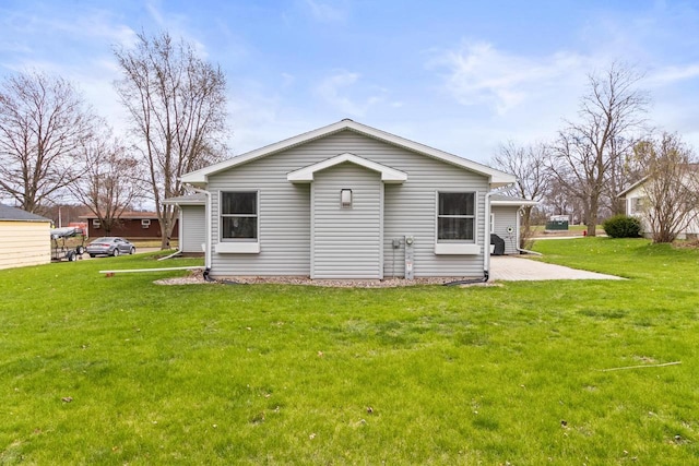 rear view of house featuring a yard and a patio