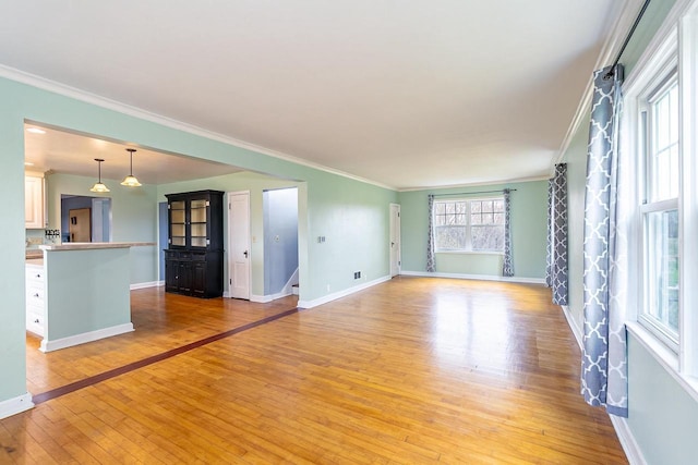 414 State Road 26, Oshkosh, WI 54904 - unfurnished living room with baseboards, ornamental molding, stairs, and light wood-style flooring