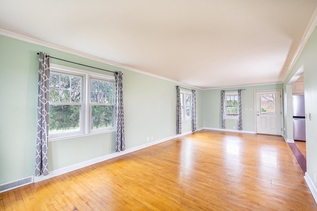 414 State Road 26, Oshkosh, WI 54904 - spare room featuring baseboards, visible vents, light wood-style floors, and ornamental molding