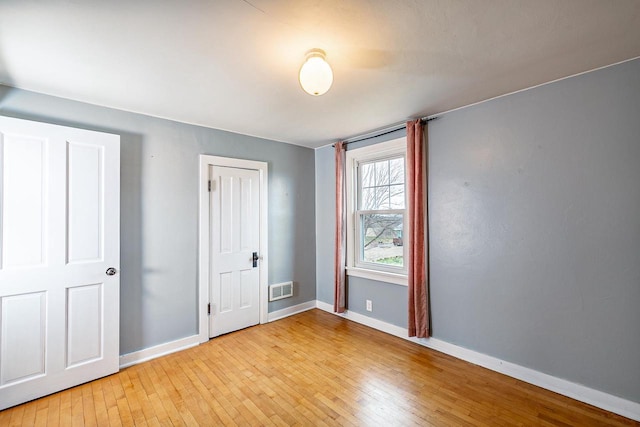 414 State Road 26, Oshkosh, WI 54904 - unfurnished bedroom with baseboards, light wood-style flooring, and visible vents
