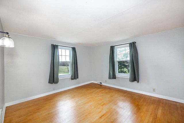 414 State Road 26, Oshkosh, WI 54904 - empty room with plenty of natural light, visible vents, light wood finished floors, and baseboards