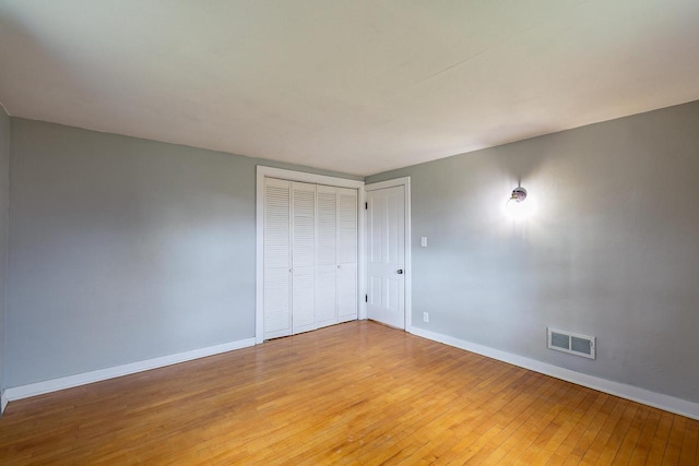 414 State Road 26, Oshkosh, WI 54904 - unfurnished bedroom featuring a closet, visible vents, light wood finished floors, and baseboards