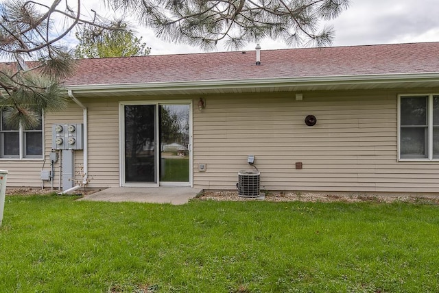 back of house with a lawn, central AC, and a shingled roof