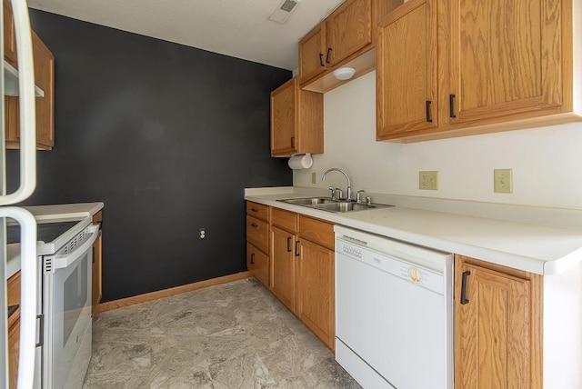 kitchen with brown cabinets, a sink, white appliances, light countertops, and visible vents