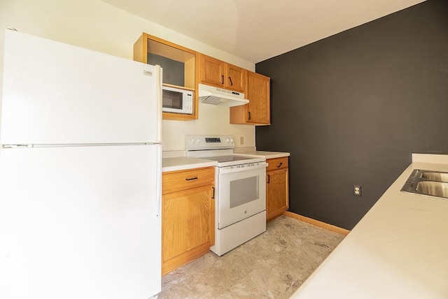 kitchen with brown cabinetry, white appliances, baseboards, light countertops, and under cabinet range hood