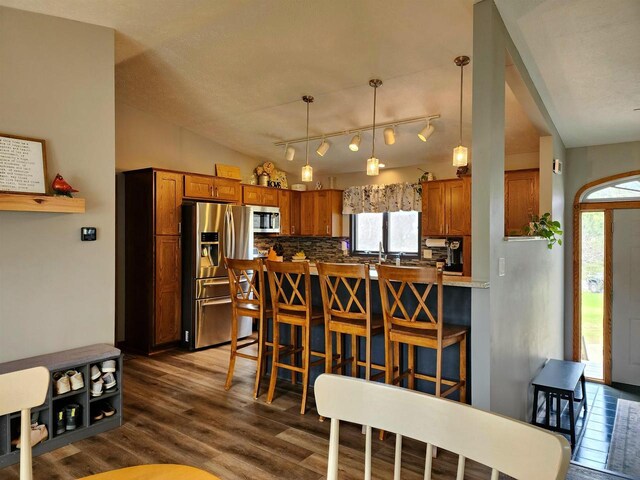 12902 Flicker Rd, Tomah, WI 54660 - dining space with vaulted ceiling, track lighting, and dark wood-style flooring