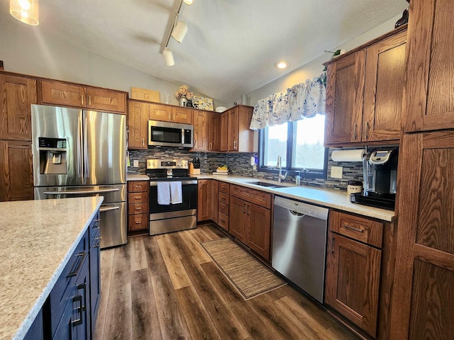 12902 Flicker Rd, Tomah, WI 54660 - kitchen featuring vaulted ceiling, a sink, stainless steel appliances, backsplash, and dark wood-type flooring