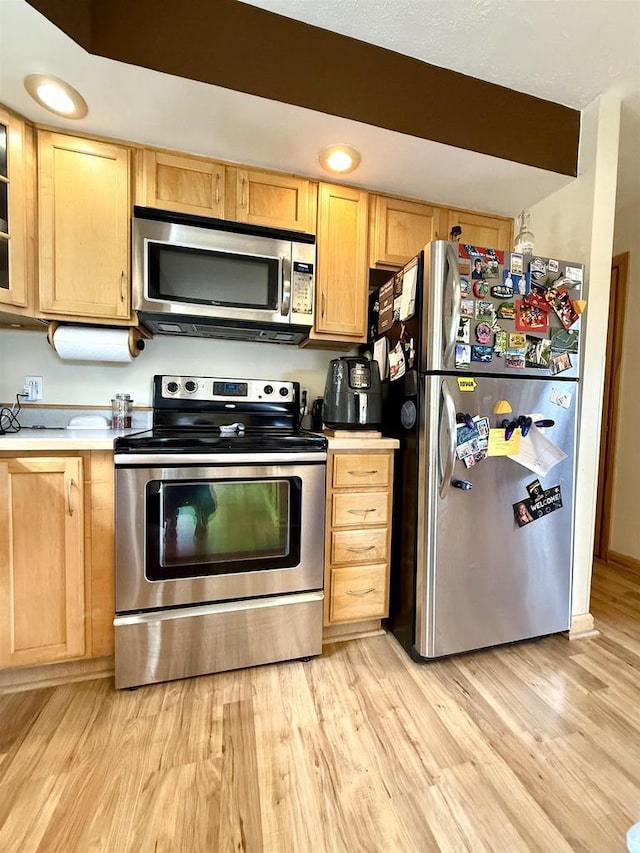 kitchen with stainless steel appliances, light wood-style flooring, and light brown cabinets