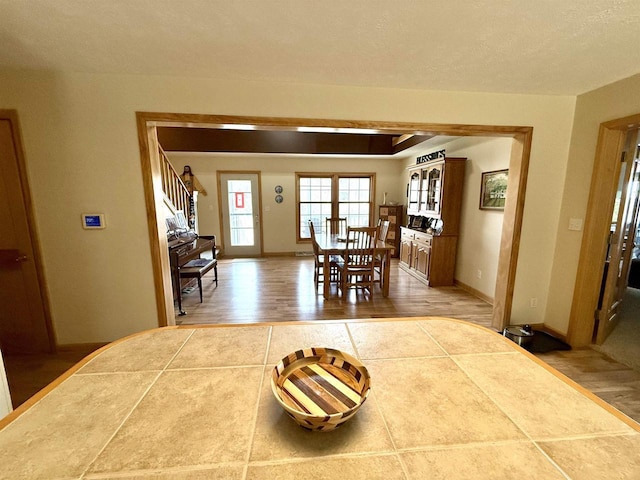 dining room with wood finished floors, baseboards, and stairway