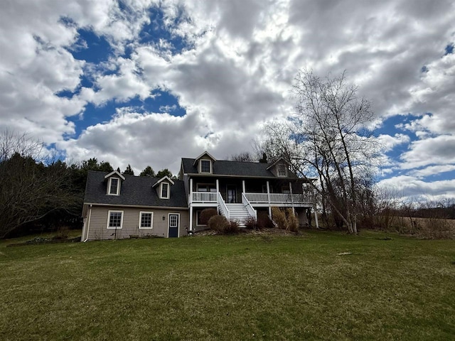 rear view of house with a lawn, a porch, and stairway