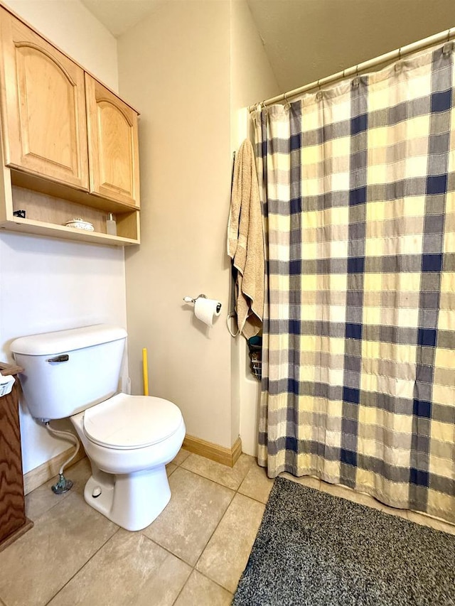 bathroom with baseboards, tile patterned flooring, a shower with shower curtain, and toilet