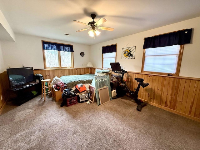 bedroom with carpet, a wainscoted wall, and wood walls