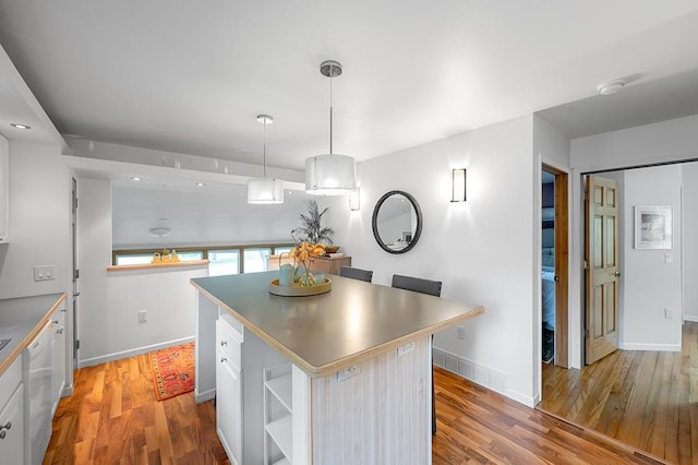 1301 Temkin Ave, Madison, WI 53705 - kitchen featuring white dishwasher, light wood-style floors, a center island, and white cabinetry