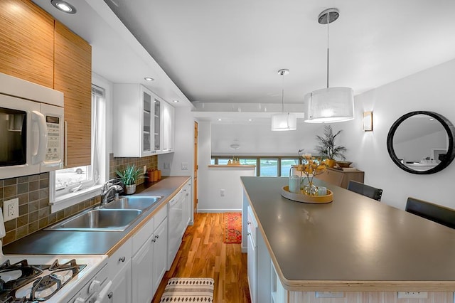 1301 Temkin Ave, Madison, WI 53705 - kitchen featuring white appliances, a sink, backsplash, light wood finished floors, and a center island