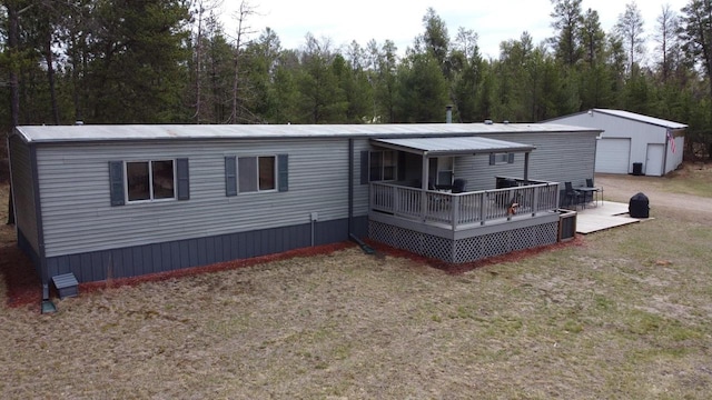 N9140 Snow Snake Trl, Necedah, WI 54646 - rear view of property featuring a garage, a forest view, a lawn, and a deck