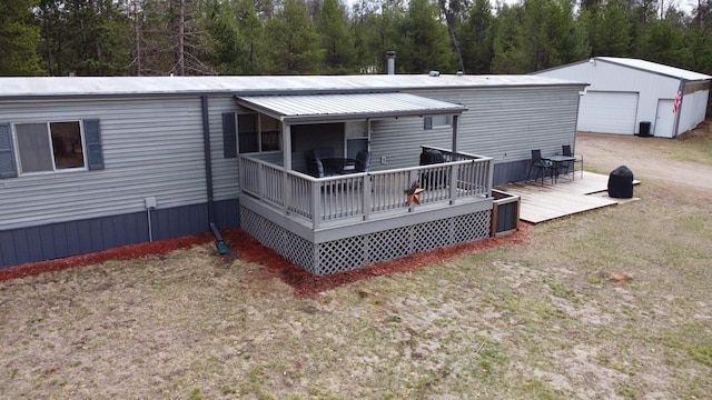 N9140 Snow Snake Trl, Necedah, WI 54646 - back of house with an outbuilding, a detached garage, a wooden deck, a lawn, and dirt driveway